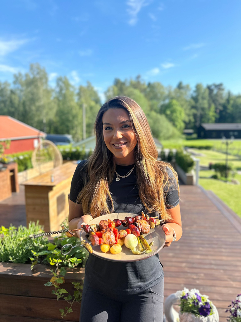 Coach utanför, håller upp lagad mat